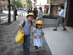 黄色い校帽をかぶり、兄妹揃って登校の道で。